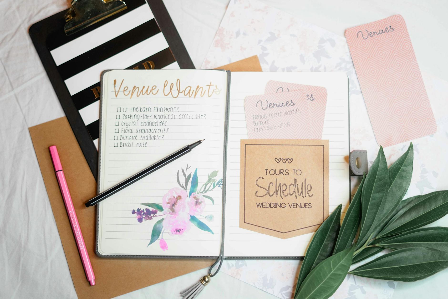Flat lay of wedding planning materials including a journal, leaves, and stationery. - ilk WordPress yazısı