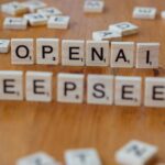 Ahşap masa üzerinde "OpenAI" ve "DeepSeek" yazan ahşap Scrabble harflerinin yakın çekimi. - Galatasaray şampiyonluk sırrı